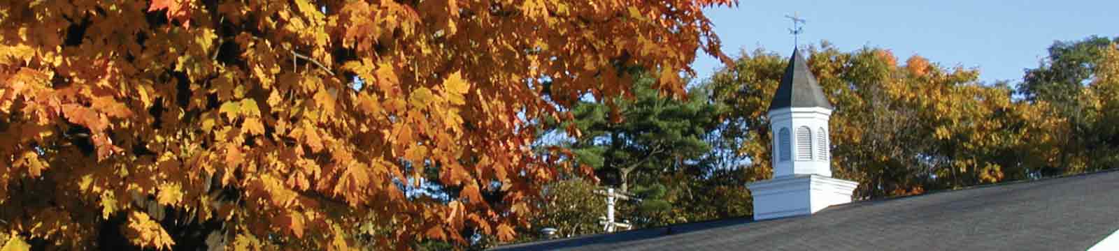The Cupola on the Top of the Willsboro Roof next to a tree of autumn leaves