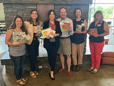 Six People Each Holding a Selection of Children's Books