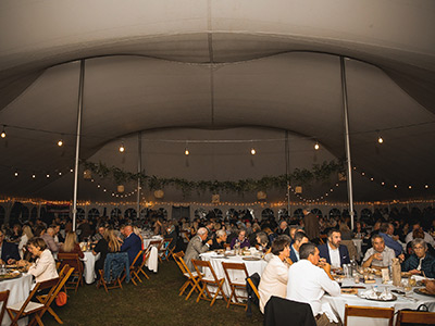 People Sitting at Tables Under a Tent