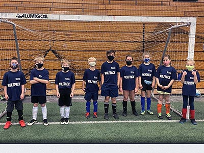 Group of Young Kids Standing Outside a Soccer Net