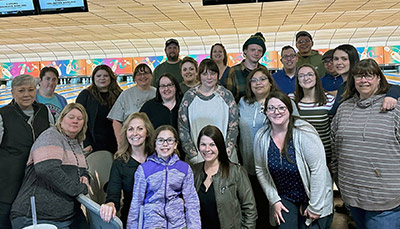 Group of People Posing for a Picture in a Bowling Alley