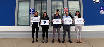 Five People Holding a Sign that Says Champlain National Bank Loves the United Way