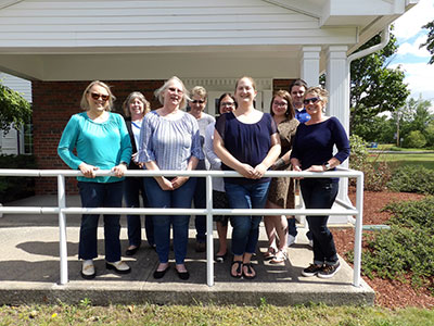 A group of people wearing jeans standing outside in Willsboro.