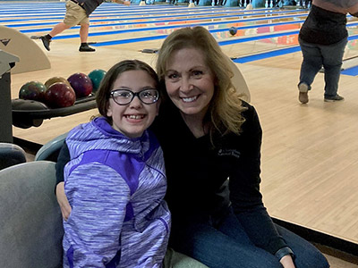 Ava and Darlene Posing for a Picture with their Arms Around Each Other