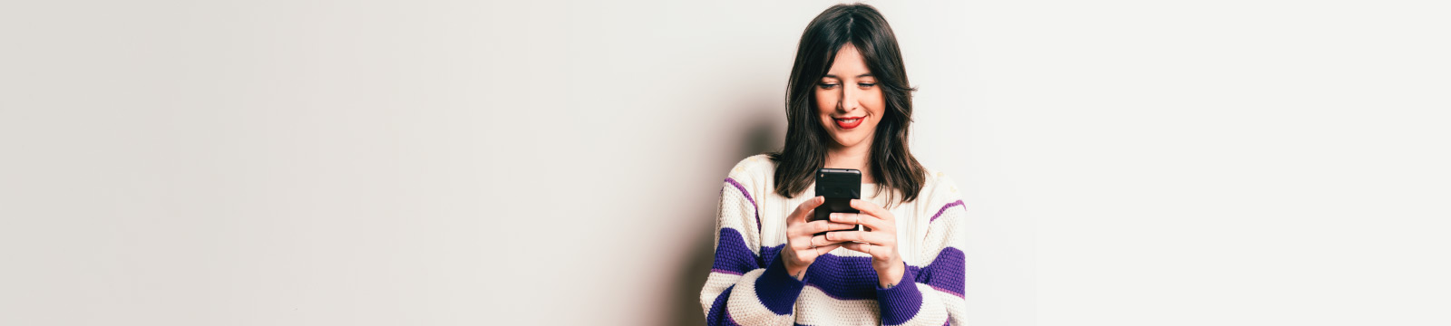 Woman Holding Cell Phone Looking at Screen