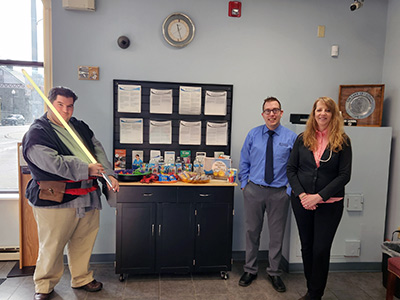 Man Holding a Light Saber Next to a Snack Table