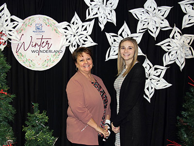 Two Women Standing in Front of Snowflakes