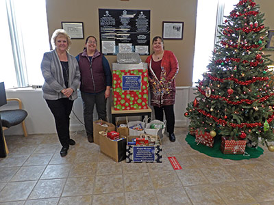 Three Women Next to Boxes and Bags of Food